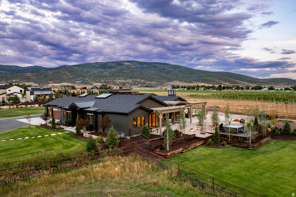 Ranch-style residence featuring a dark gray exterior and an expansive green lawn