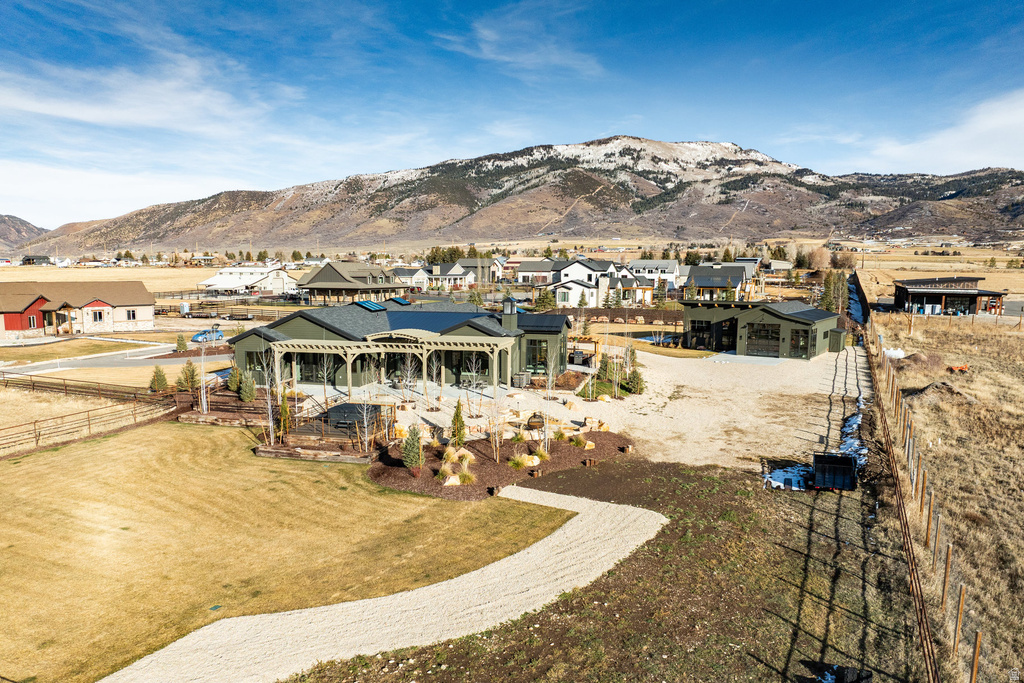 Expansive property featuring a contemporary-style residence with multiple detached structures, a large patio area, and mature landscaping