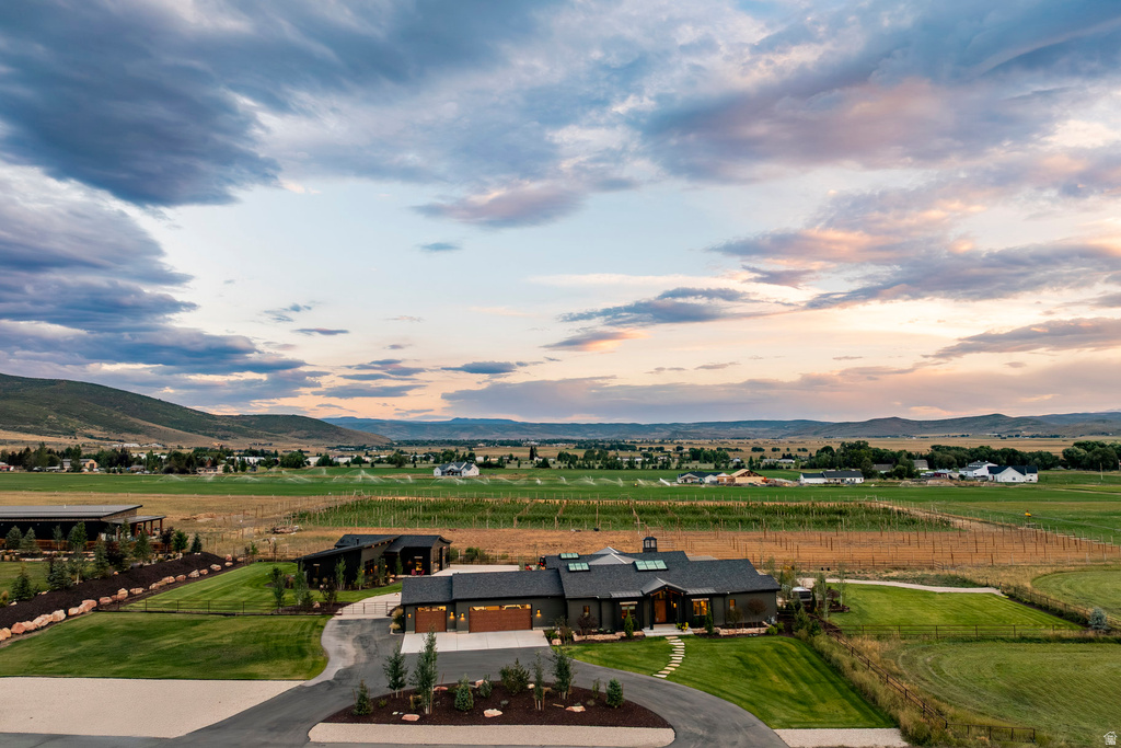 Modern ranch-style residence featuring a dark facade, a cupola, and an attached three-car garage with wood-finish doors