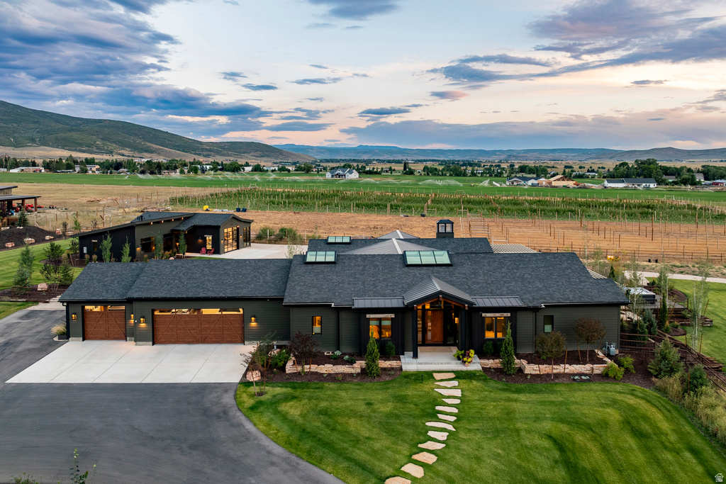 Contemporary multi-structure residence featuring dark exterior siding, a shingle roof, and multiple skylights