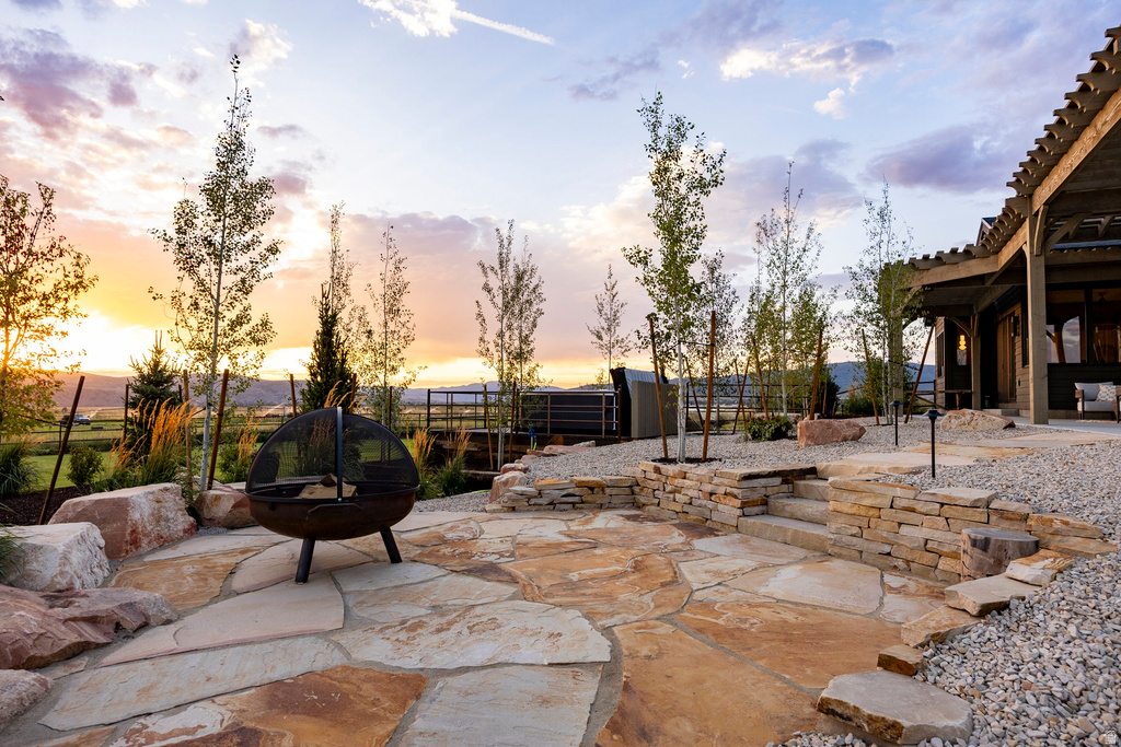 Expansive flagstone patio with a built-in stone retaining wall, complemented by a gravel ground cover