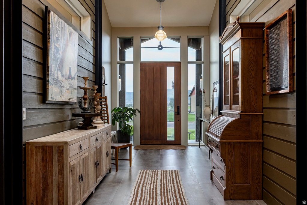 Entryway featuring a wood-finish door with a vertical glass panel, flanked by tall side windows