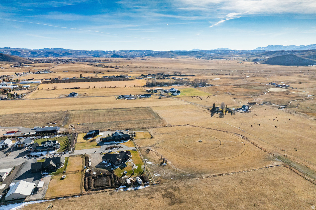 Expansive rural landscape featuring distant mountains, open fields, and scattered residential properties