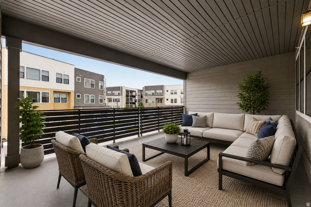 Covered outdoor patio featuring a slatted ceiling, horizontal plank siding, and a black slatted railing