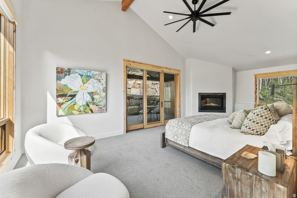 Vaulted ceiling room featuring a built-in fireplace, natural wood trim windows, and glass sliding doors