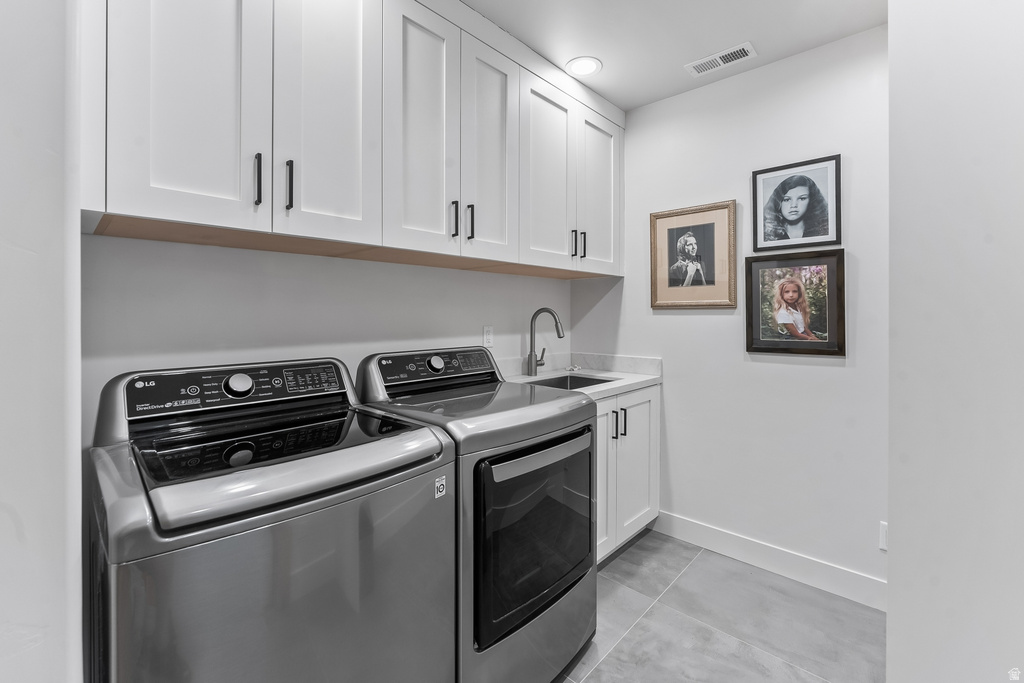 Dedicated laundry space featuring white shaker cabinetry, an integrated sink with a stainless steel faucet, and light grey countertop