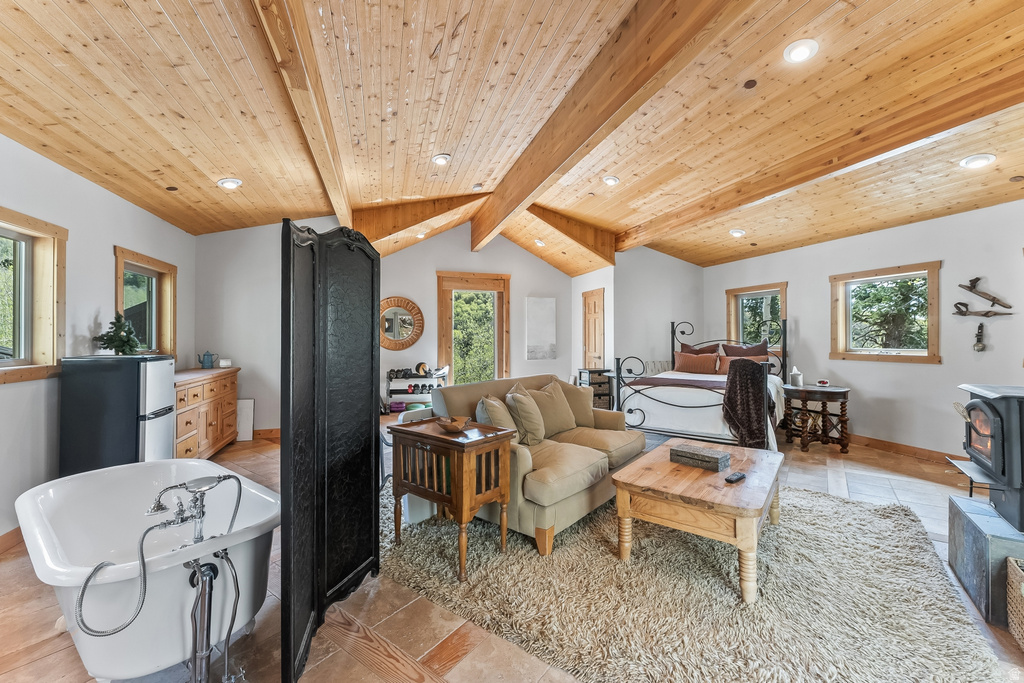 Vaulted wood-paneled ceilings with exposed beams, recessed lighting, and natural wood window trim