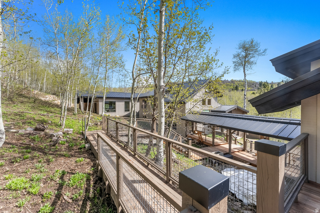 Wood-plank walkway with cable railings extending towards the property