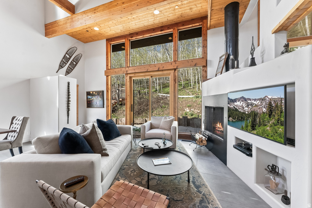 Living area featuring a floor-to-ceiling fireplace with integrated wood storage, a built-in entertainment system, and an expansive window wall