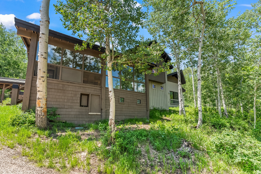 Contemporary exterior with expansive floor-to-ceiling windows, wood shake siding, and a sloped roofline