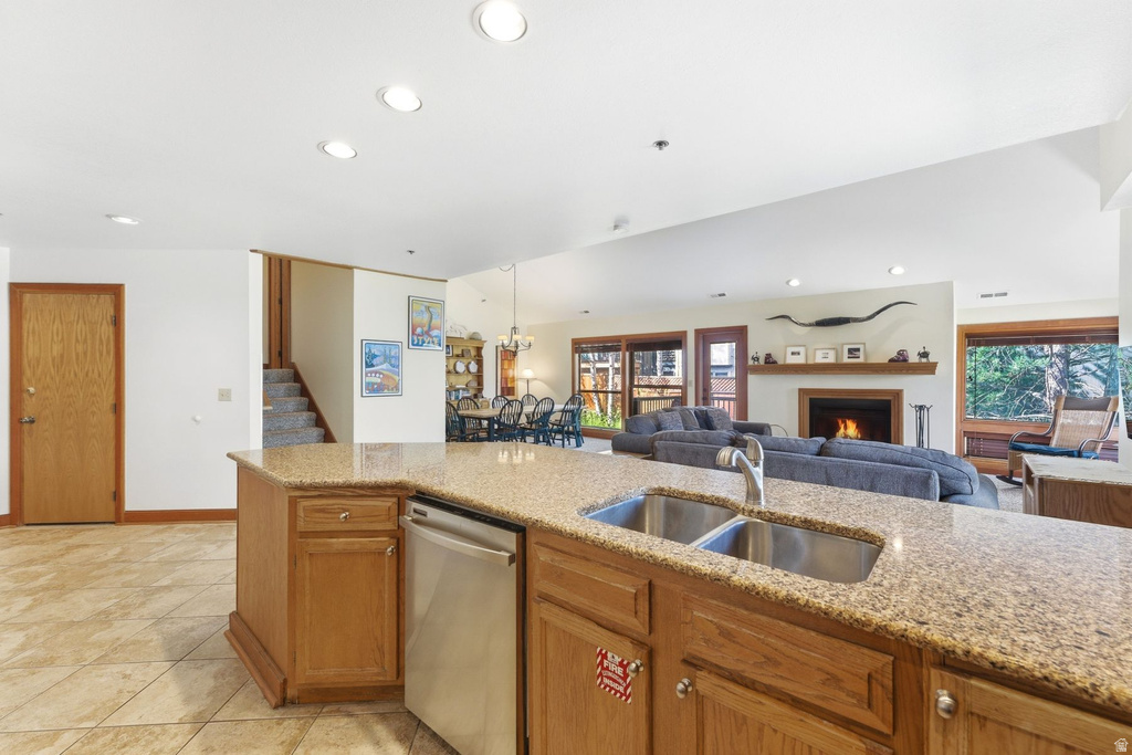 Kitchen island featuring a double basin stainless steel sink, pull-down faucet, and integrated dishwasher