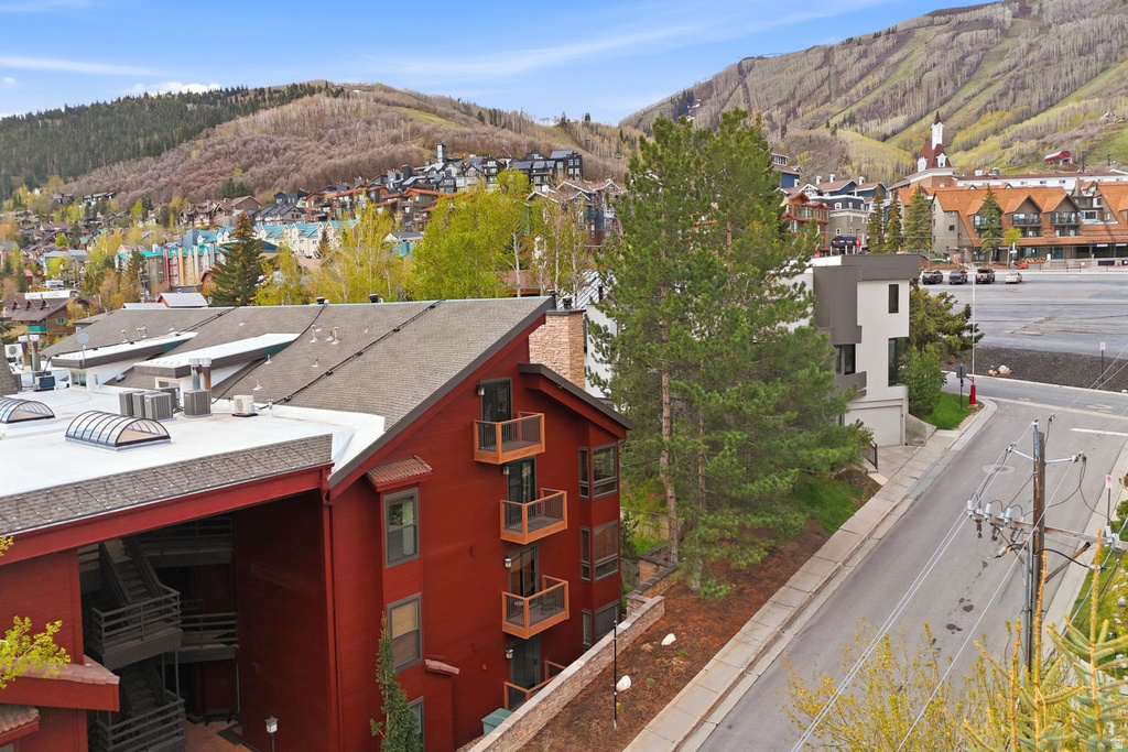 Multi-story property featuring a red siding exterior and multiple private balconies with wood railings