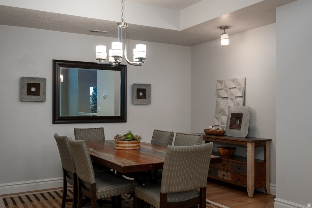 Dining area featuring a tray ceiling with recessed lighting and a contemporary chandelier