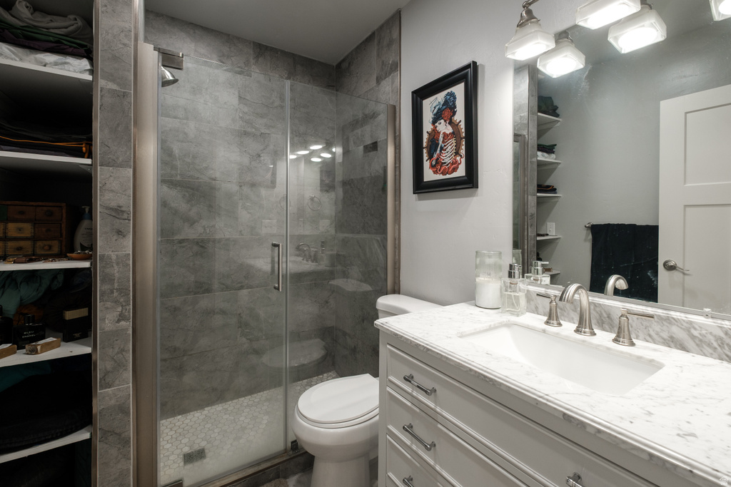 Contemporary bathroom featuring a frameless glass shower enclosure with large format grey tile surround and a mosaic tile pan