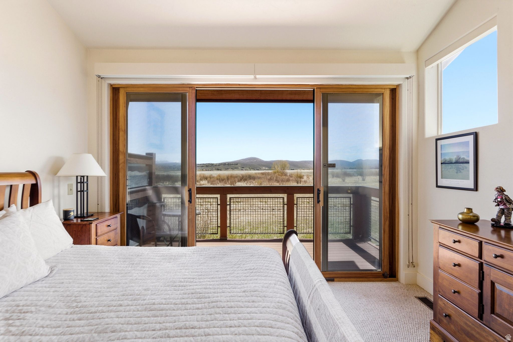 Room featuring a large sliding glass door opening to an exterior deck with metal railing