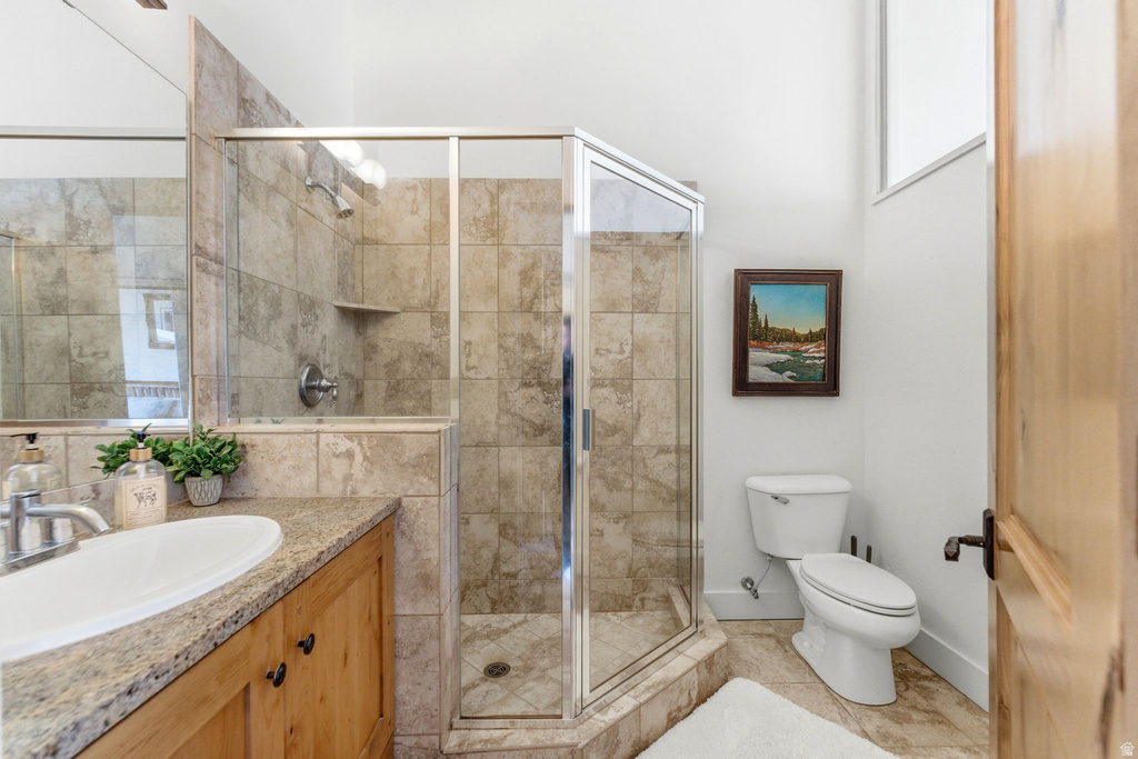 Walk-in shower with natural stone tile surround and glass enclosure