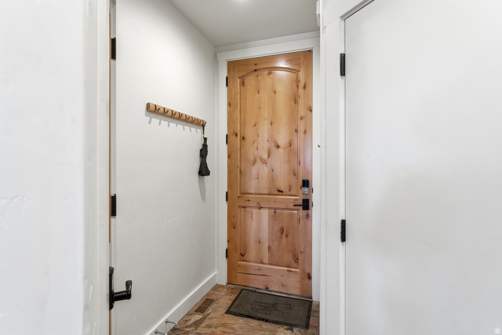 Warm wood-paneled door featuring a smart lock system