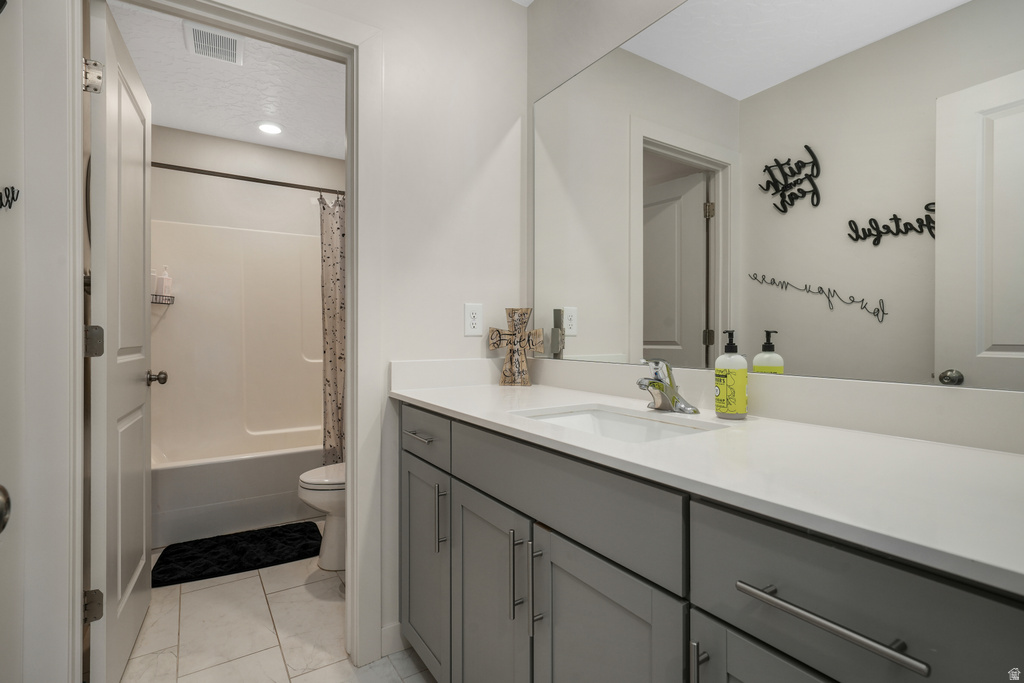 Bathroom vanity with an integrated sink, broad mirror, and grey cabinetry