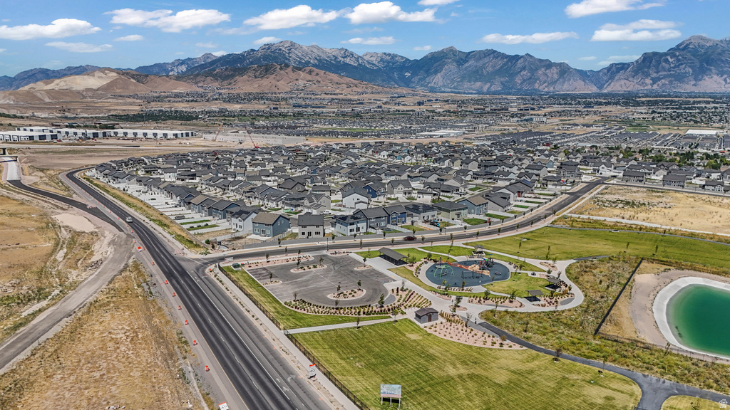 Expansive residential development featuring modern homes, a community park with playground equipment, walking paths, and a retention pond