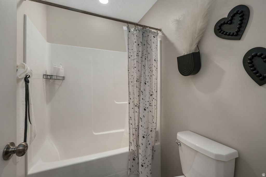 White acrylic tub and shower combination with a curved shower rod