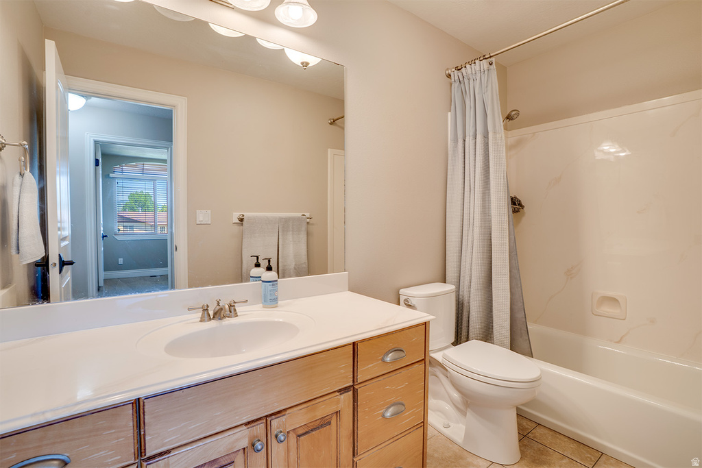 Bathroom featuring a wood-finish vanity with an integrated sink and light-colored countertop