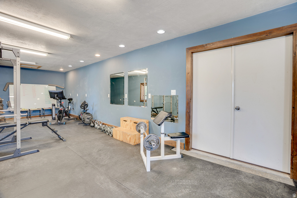 Dedicated room featuring durable rubber flooring, ceiling-mounted fluorescent lighting, recessed ceiling lights, and blue painted walls