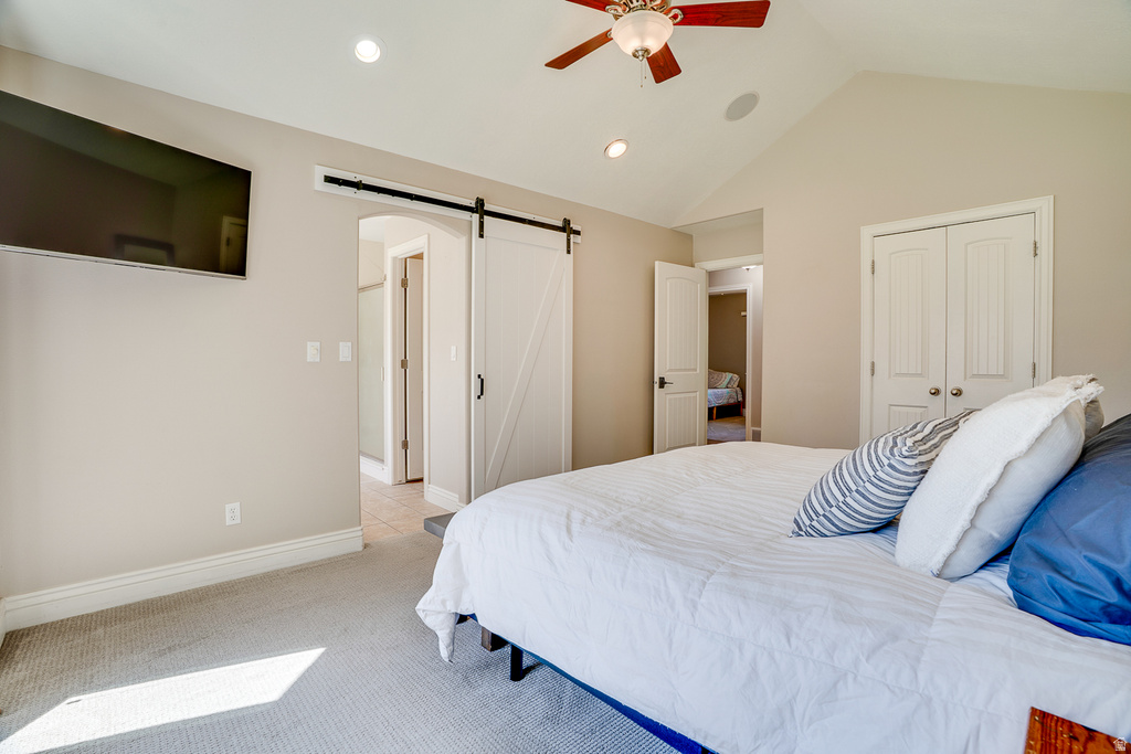 Vaulted ceiling bedroom featuring a ceiling fan with integrated lighting, recessed lighting, and a white barn door