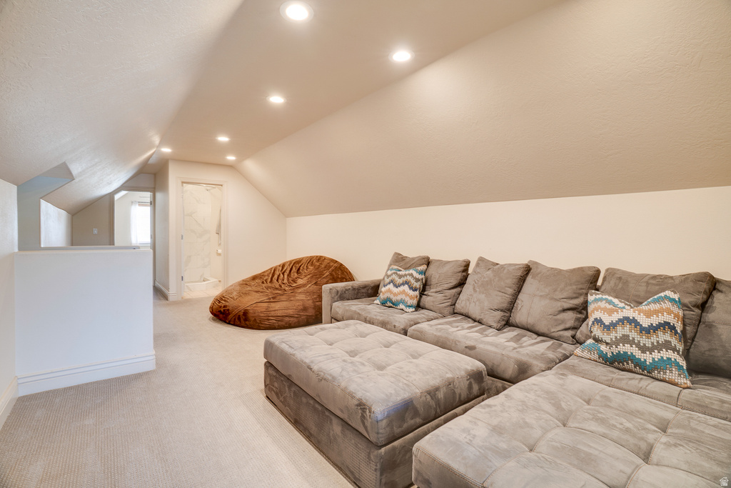 Carpeted loft area featuring a sloped ceiling with recessed lighting