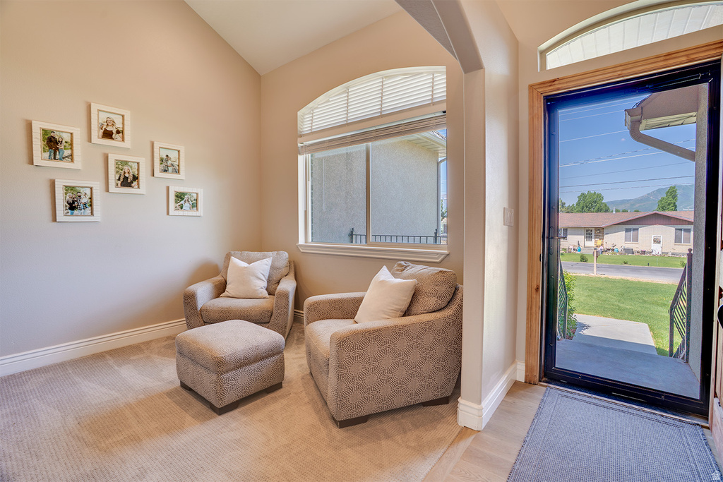 Arched entryway opening to an inviting space with vaulted ceilings