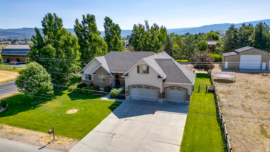 Two-story residence featuring a brick and stucco facade, an attached three-car garage with arched entrances, and a large concrete driveway