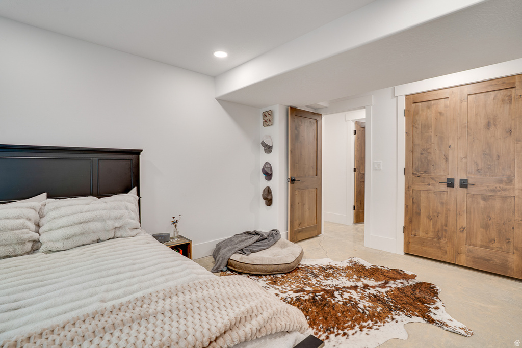 Bedroom featuring light-toned flooring, recessed lighting, and a dark wood headboard
