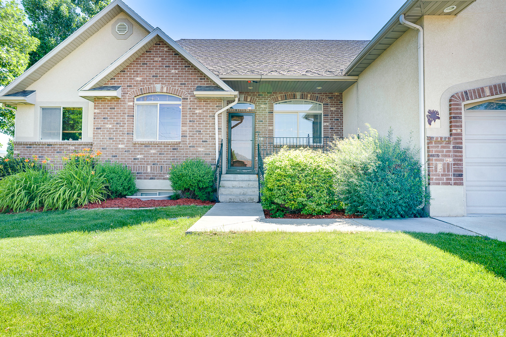 Brick and stucco exterior with an arched entry window and an attached garage