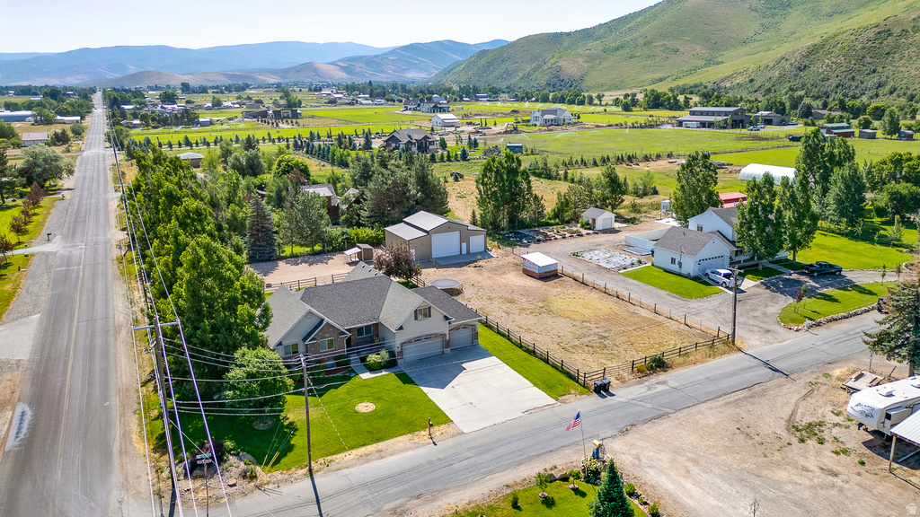 Expansive property featuring a residence with an attached two-car garage, a detached workshop, a separate storage building, a substantial concrete driveway, and established landscaping