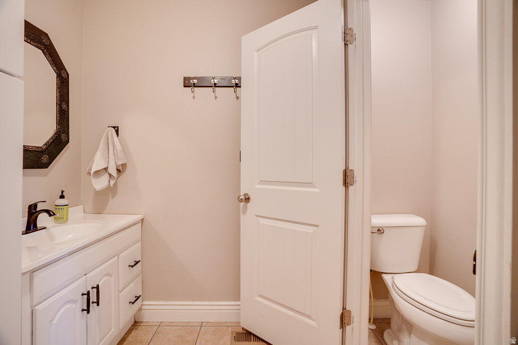 Bathroom featuring a white vanity with built-in storage, a basin sink, and a dark bronze faucet
