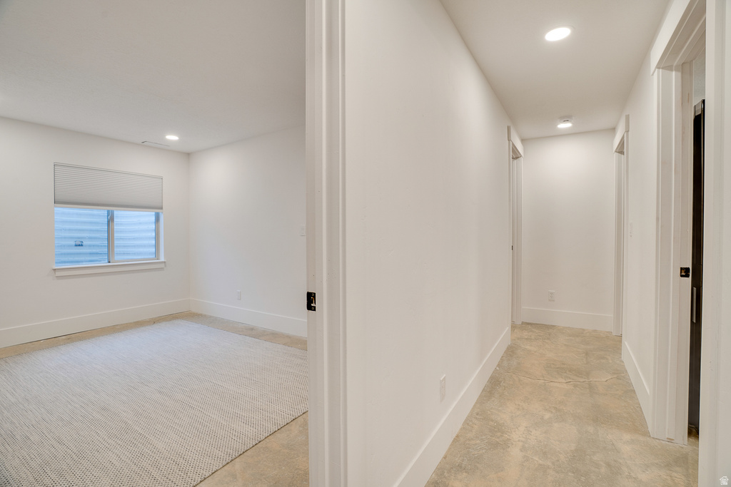 Hallway featuring recessed lighting and durable tile-finish flooring