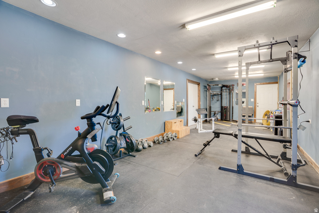 Dedicated exercise space featuring rubber flooring, recessed lighting, and a neutral wall color
