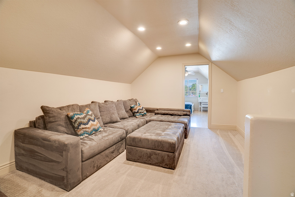 Attic space featuring sloped ceilings, recessed lighting, and light-toned carpeting