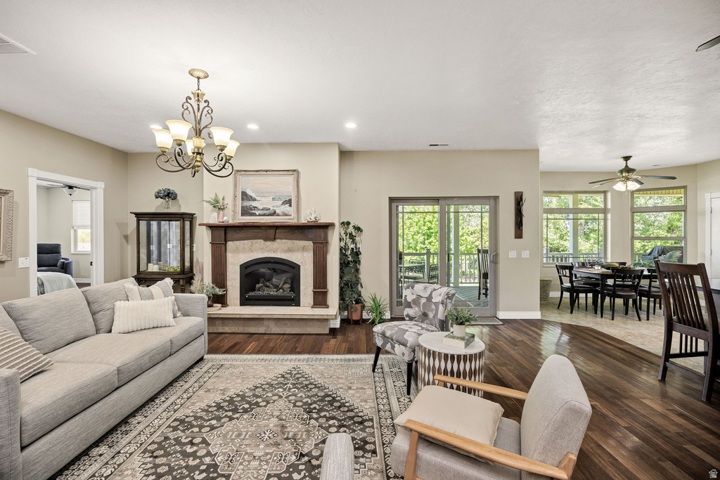 Living area featuring a stone fireplace with a wood mantle, wood-finish flooring, and recessed lighting