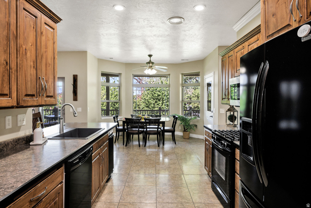 Kitchen featuring wood-finish cabinetry, black appliances, and a double basin sink