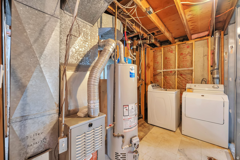 Utility room featuring a furnace, water heater, washer, and dryer
