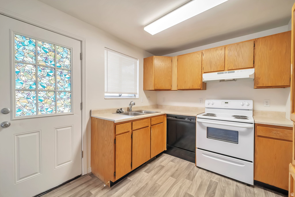 Kitchen featuring wood cabinetry, laminate countertops, wood-finish flooring, and white appliances