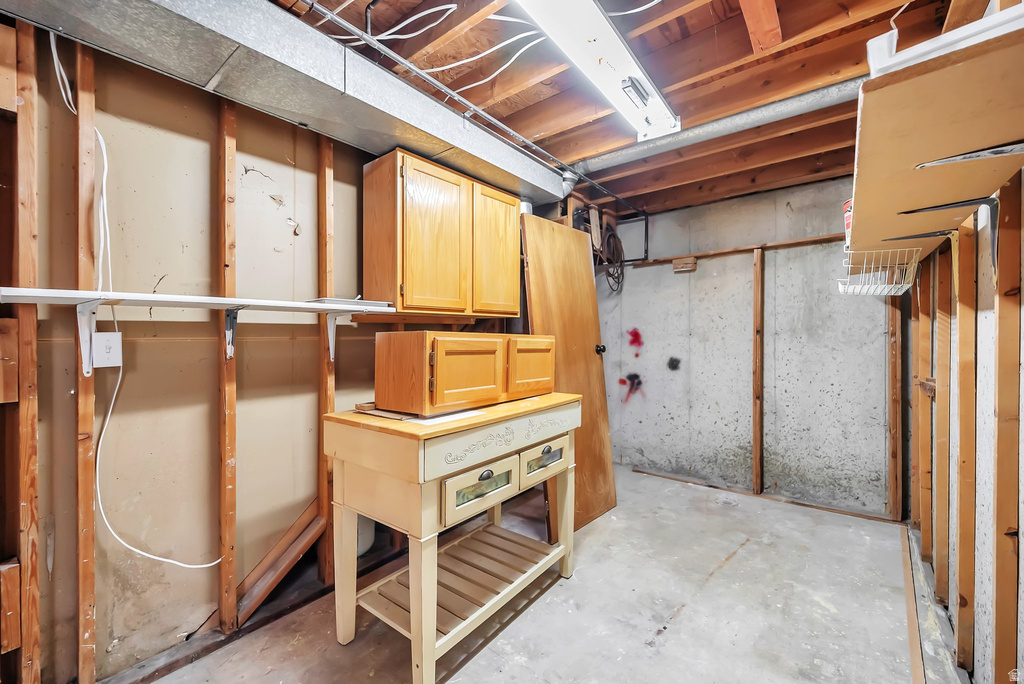 Basement area featuring exposed concrete walls and wood framing