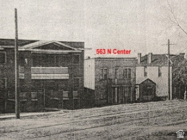 Historical Property Photograph. Displaying an urban streetscape with multiple structures and an address identifier
