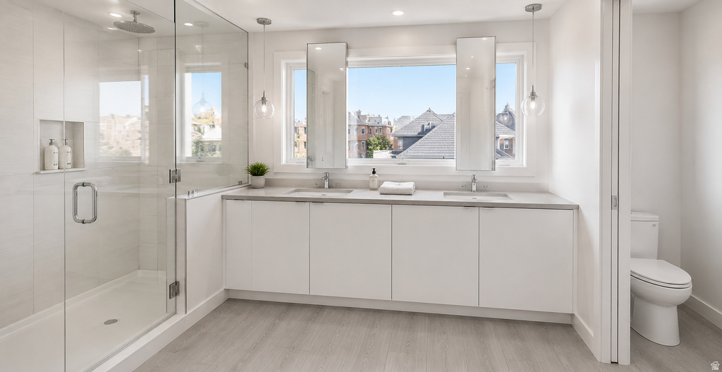 Contemporary bathroom featuring a spacious glass-enclosed shower with a built-in niche, dual floating vanities with undermount sinks, and two large windows