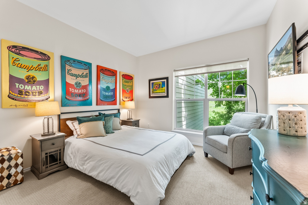 Carpeted room featuring a large window, neutral wall paint, and a built-in mounted television