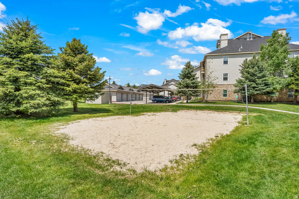 Outdoor sand volleyball court surrounded by manicured green lawn