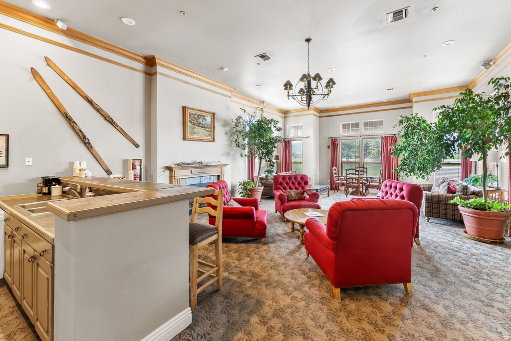 Spacious common area featuring a built-in wet bar with wood cabinetry and countertop, a chandelier, a fireplace with a decorative mantel, and multiple sets of glass doors