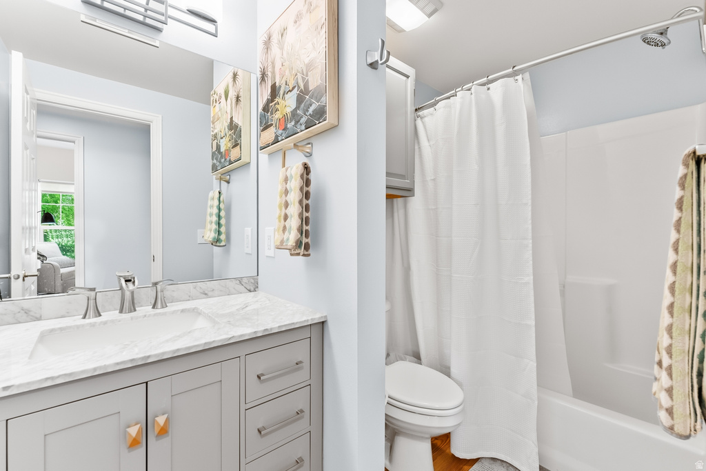 Bathroom with a light gray vanity, integrated sink, and brushed nickel hardware