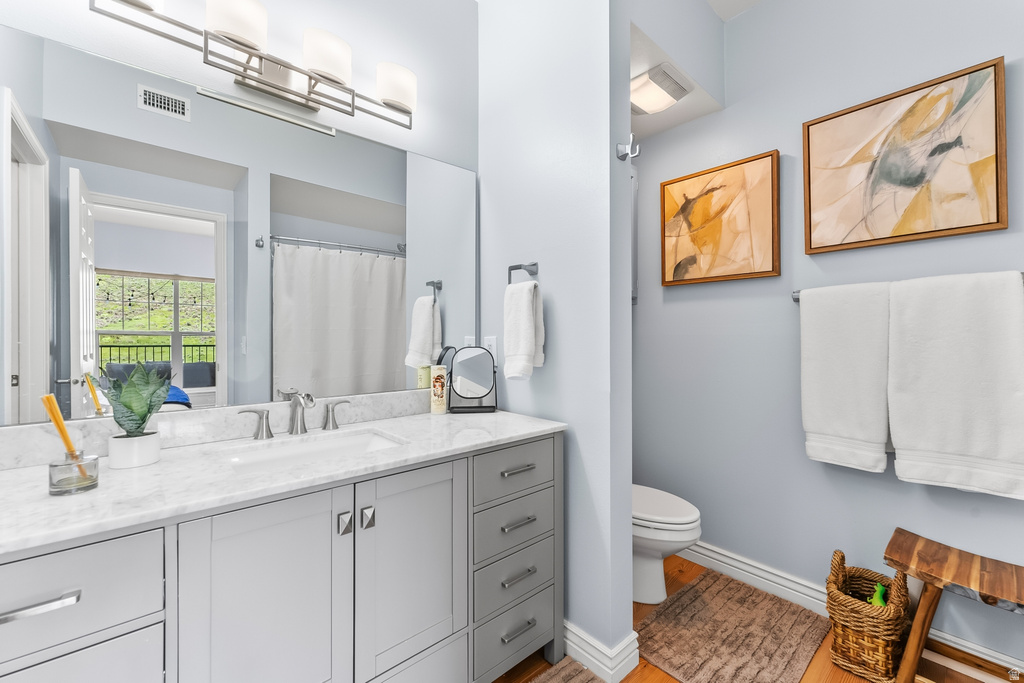 Bathroom featuring a double vanity with a light gray cabinet base, white countertop, and dual sinks