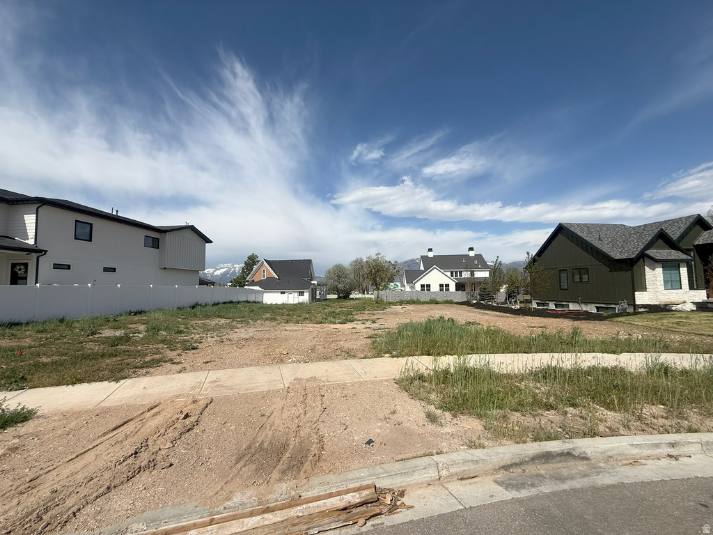 Level building lot featuring a concrete sidewalk and curb along the street frontage